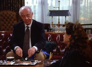 Ian Abercrombie as Mr. Pitt in Seinfeld eating a chocolate bar with a fork and knife